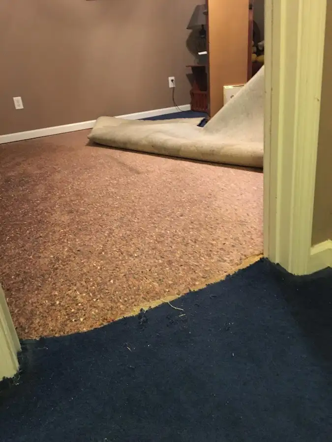 Carpet pad removal revealing water damage during Water Mitigation Services in Vernon